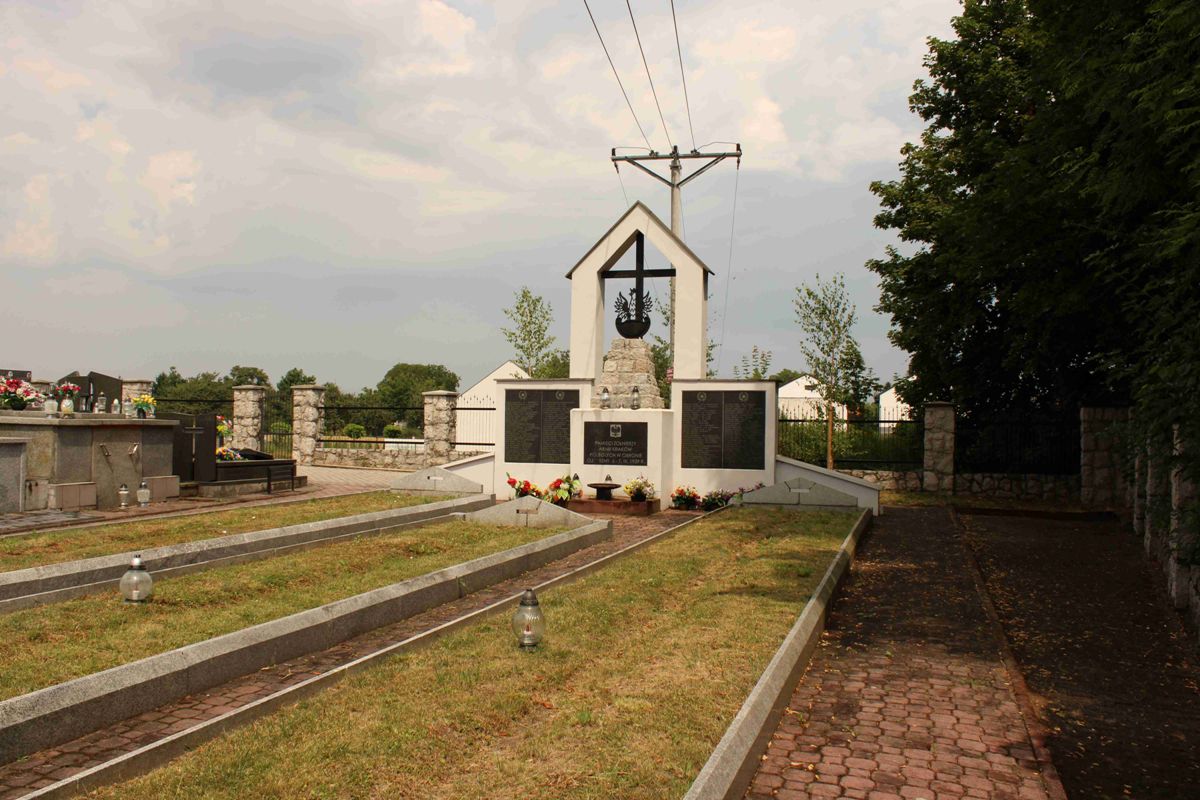 Kwatera wojenna żołnierzy Wojska Polskiego z 1939 r. na cmentarzu parafialnym w Proszowicach. Widok na mogiły i pomnik z narożnika kwatery.